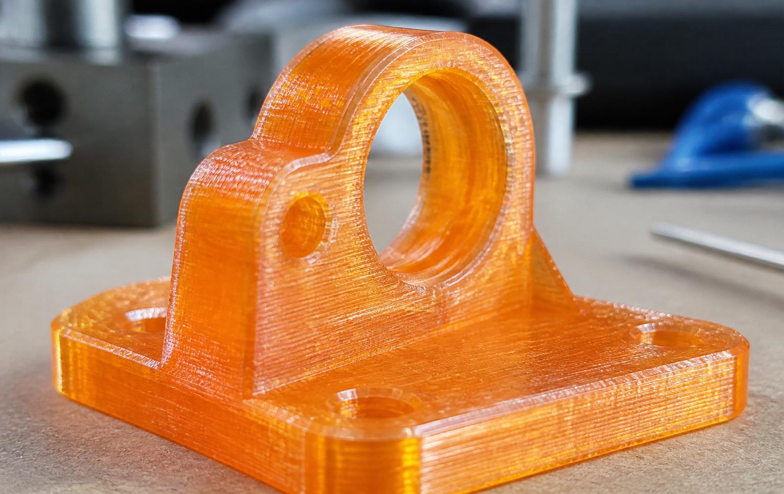 PETG part — translucent orange bracket with visible layer lines